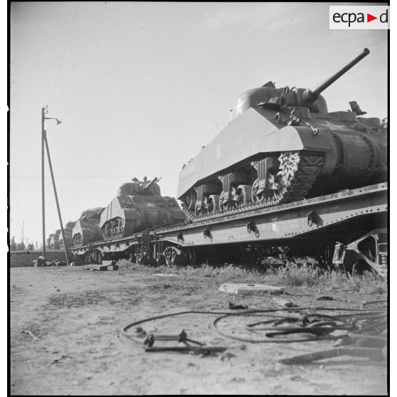 En gare de Boufarik, des chars moyens Sherman M4 A4 américains, destinés au 5e RCA (régiment de chasseurs d'Afrique) de la 1re DB (division blindée), sont embarqués sur un wagon porte-chars.