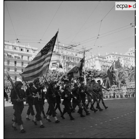 Défilé des drapeaux américain, français et britannique et de leurs gardes lors de la fête de Jeanne d'Arc à Alger.