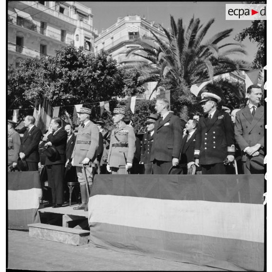 Dans la tribune officielle, les généraux d'armée Henri Giraud, commandant en chef civil et militaire, et Georges Catroux assistent au défilé interallié qui a lieu dans le cadre de la célébration de la fête de Jeanne d'Arc à Alger.