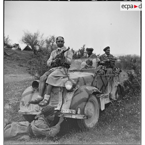 Des goumiers du IIe Tabor du 1er GTM (groupe de tabors marocains) de la 1re DMM (division de marche du Maroc) prennent la pose à bord d'une voiture de liaison FIAT 508 CM prise aux Italiens, dans le secteur de Siliana.