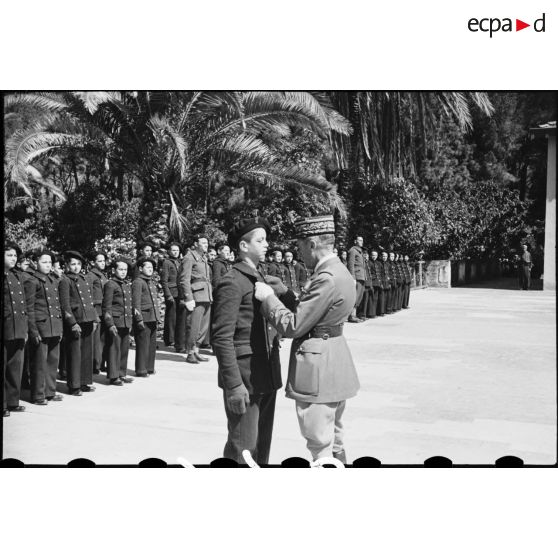 Le général d'armée René Prioux, major général des forces terrestres, remet la croix de guerre avec étoile à l'enfant de troupe Vincent, lors de la cérémonie de remise de drapeau de l'EMPNA (Ecole militaire préparatoire nord-africaine) d'Hammam-Righa.