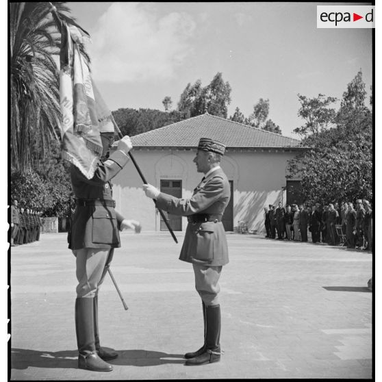 Lors d'une cérémonie, le général d'armée René Prioux, major général des forces terrestres, remet le drapeau de l'EMPNA (Ecole militaire préparatoire nord-africaine) d'Hammam-Righa au colonel Faure, commandant l'école.
