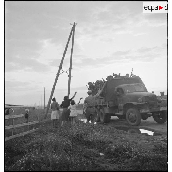 Aux portes de Bizerte, la population civile salue l'arrivée de soldats du CFA (Corps franc d'Afrique), embarqués à bord d'un GMC.