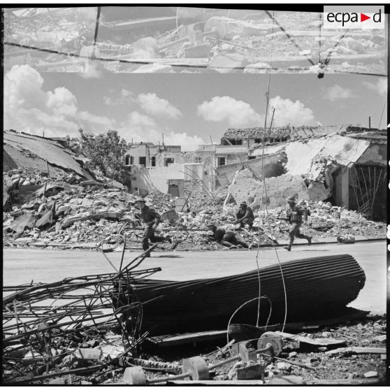 Des soldats du CFA (Corps franc d'Afrique) progressent dans Bizerte en ruine.