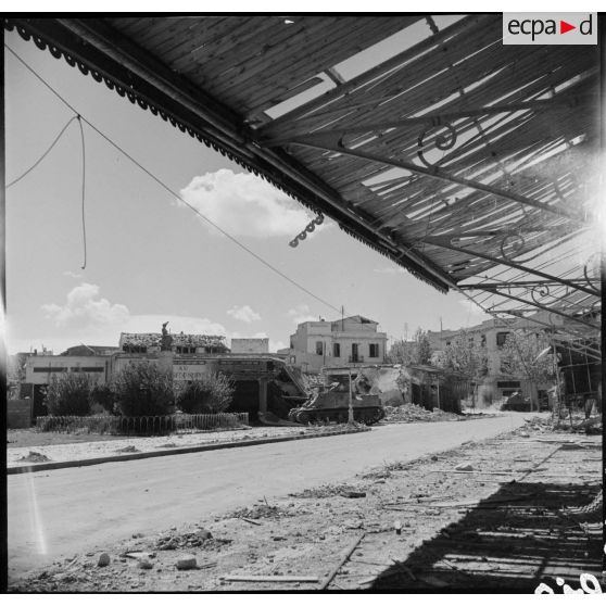 Un char M3 Lee, appartenant probablement à une unité américaine, progresse dans Bizerte en ruine afin de nettoyer un ilôt de résistance.