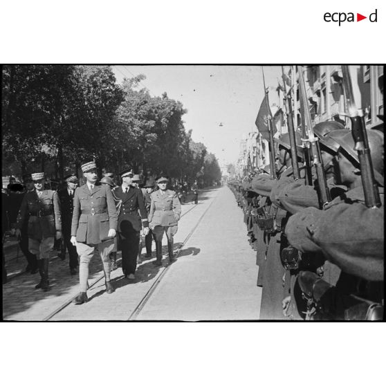 En visite à Tunis, libérée le 7 mai par les troupes britanniques, le général d'armée Henri Giraud, commandant en chef civil et militaire, passe une unité de tirailleurs algériens en revue au cours d'une cérémonie.