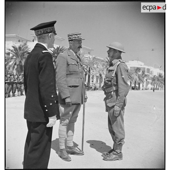 Au cours d'une cérémonie, le général d'armée Henri Giraud, commandant en chef civil et militaire, félicite un officier supérieur.