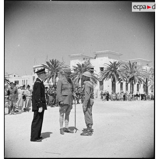Au cours d'une cérémonie, le général d'armée Henri Giraud, commandant en chef civil et militaire, félicite un officier supérieur.
