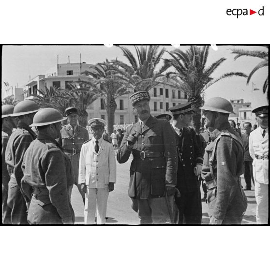 Au cours d'une cérémonie, le général d'armée Henri Giraud, commandant en chef civil et militaire, s'entretient et félicite des soldats du CFA (Corps franc d'Afrique), en présence du commandant Durand, commandant la 1re demi-brigade du CFA qui a participé à la prise de la ville de Bizerte.