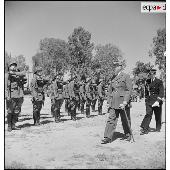 Sur l'aérodrome de Boufarik, le général d'armée Henri Giraud, commandant en chef civil et militaire, passe en revue le détachement qui doit rendre les honneurs au général de Gaulle à sa descente d'avion.