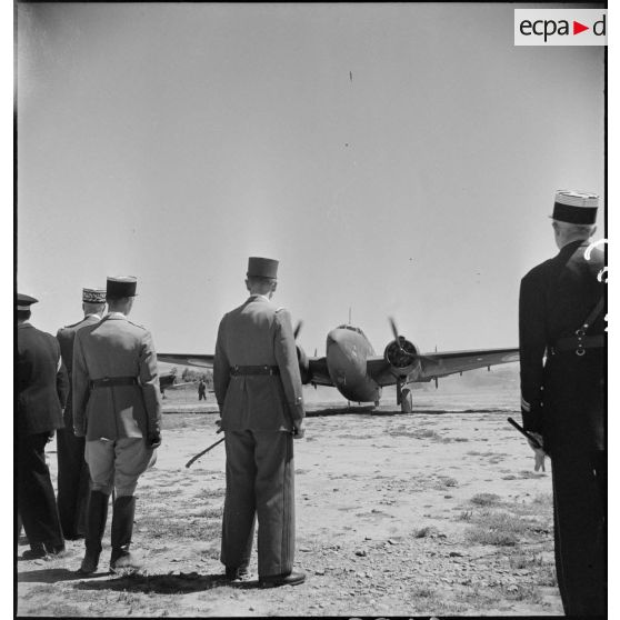 Sur l'aérodrome de Boufarik, le général d'armée Henri Giraud, commandant en chef civil et militaire, et une délégation, regardent atterrir l'appareil transportant le général de Gaulle.