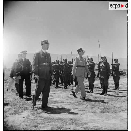 Le général de Gaulle et le général d'armée Henri Giraud, commandant en chef civil et militaire, passent en revue le détachement qui leur rend les honneurs sur l'aérodrome de Boufarik.