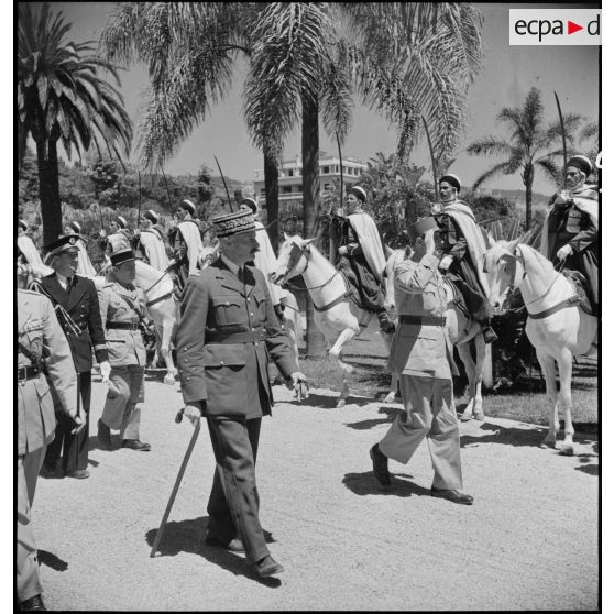 Au Palais d'été d'Alger, accompagné notamment du général d'armée Henri Giraud, commandant en chef civil et militaire, le général de Gaulle salue la garde d'honneur de spahis algériens.