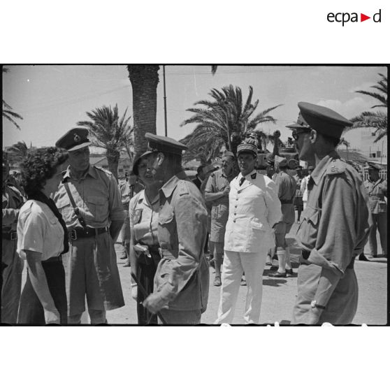 Lors d'une visite en Tunisie, le roi George VI, souverain britannique, félicite une éclaireuse du mouvement scout qui a fait évader des soldats britanniques pendant l'occupation allemande de Tunis.