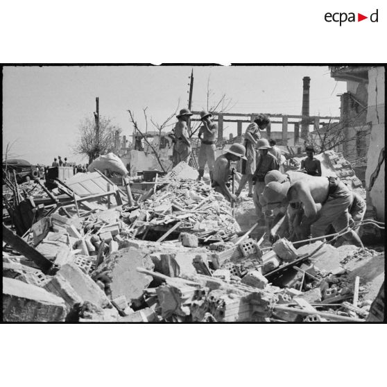 Recherche de victimes parmi les ruines suite à l'explosion d'un wagon de munitions en gare de Maison-Carrée le 4 juillet 1943.