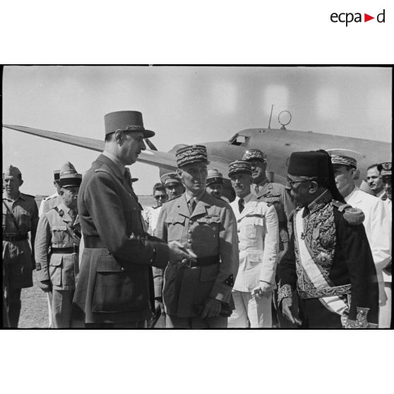 A son arrivée sur l'aérodrome d'El-Aouina de Tunis, le général de Gaulle, co-président du CFLN (Comité français de la Libération nationale), rencontre un représentant du bey de Tunis et le général de division Charles Mast, résident général de France en Tunisie.