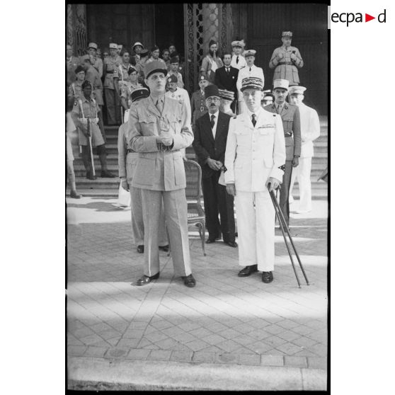Sur le parvis de la cathédrale Saint-Vincent-de-Paul de Tunis, le général de Gaulle, co-président du CFLN (Comité français de la Libération nationale), et le général de division Charles Mast, résident général de France en Tunisie, assistent à un défilé.