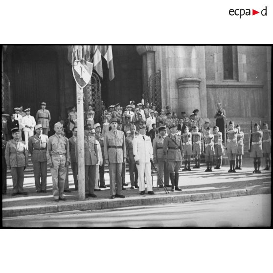 Sur le parvis de la cathédrale Saint-Vincent-de-Paul de Tunis, le général de Gaulle, co-président du CFLN (Comité français de la Libération nationale), et le général de division Charles Mast, résident général de France en Tunisie, assistent à un défilé des troupes ayant participé à la campagne de Tunisie.