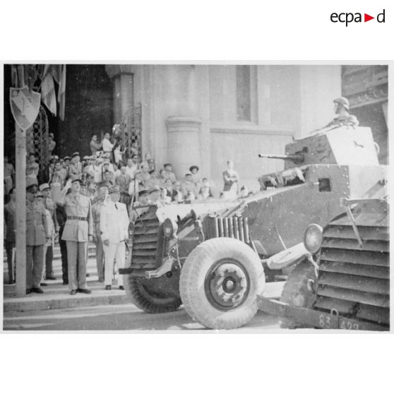 Sur le parvis de la cathédrale Saint-Vincent-de-Paul de Tunis, le général de Gaulle, co-président du CFLN (Comité français de la Libération nationale), salue le passage d'AMD Laffly 80 (automitrailleuses de découverte).