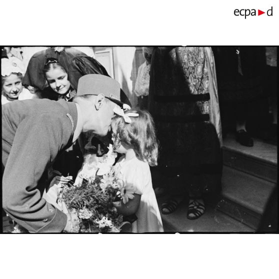 Au cours de sa visite à Tunis, le général de Gaulle, co-président du CFLN (Comité français de la Libération nationale), embrasse une fillette d'une délégation d'Alsaciens-Lorrains qui lui offre des fleurs.