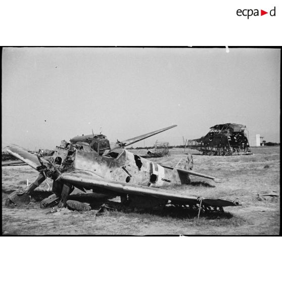Sur l'aérodrome d'El-Aouina de Tunis, au premier plan l'épave d'un chasseur allemand Messerschmitt Bf 109 et au second, la carcasse d'un planeur de transport Messerschmitt Me-323 Gigant.
