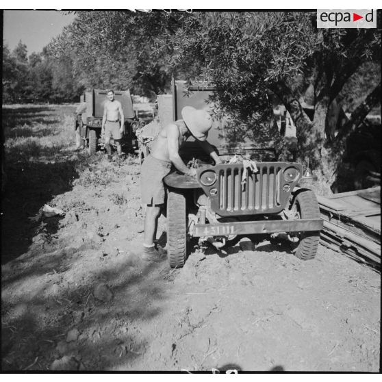 Entretien du moteur d'une jeep Ford GPW dans un cantonnement au cours d'une manoeuvre d'entraînement d'unités du CEF (corps expéditionnaire français) dans le Sud algérien.