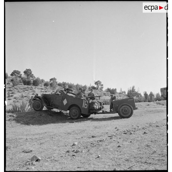 Scout-car M3A1 du 3e Régiment de spahis algériens de reconnaissance (RSAR) à l'entraînement, tractant une remorque blindée M8 au cours d'une manoeuvre du corps expéditionnaire français (CEF) dans le Sud algérien.