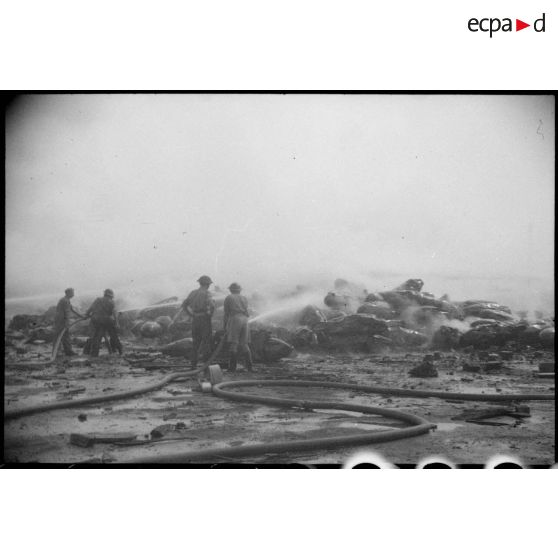 Suite à l'incendie d'un navire pétrolier, des pompiers éteignent le feu qui s'est propagé dans le port d'Alger.