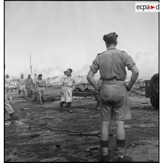 Les victimes de l'incendie d'un navire pétrolier sont brancardées sur un quai du port d'Alger.