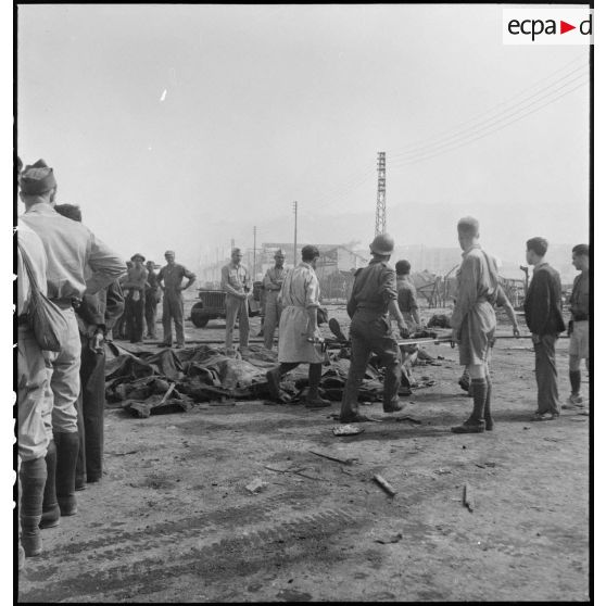 Les victimes de l'incendie d'un navire pétrolier sont brancardées sur un quai du port d'Alger.