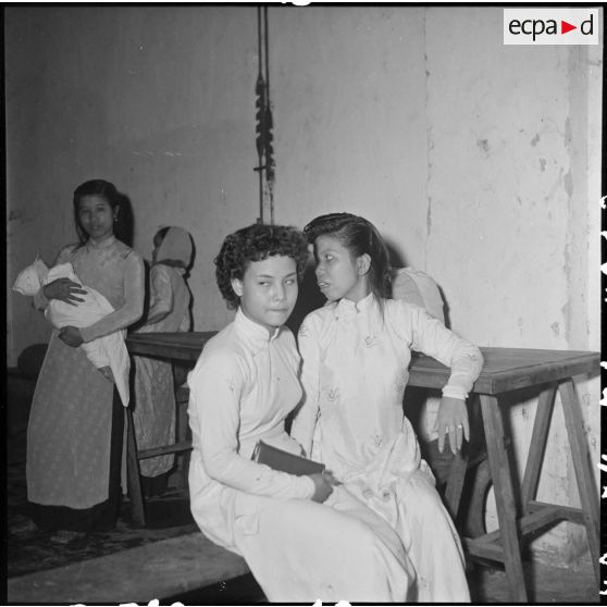 Deux jeunes femmes réfugiées attendent d'être pesées pour pouvoir monter dans l'avion du pont aérien.