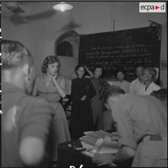 Des réfugiés sont informés des conditions de leur départ au centre d'évacuation d'Hanoï.	