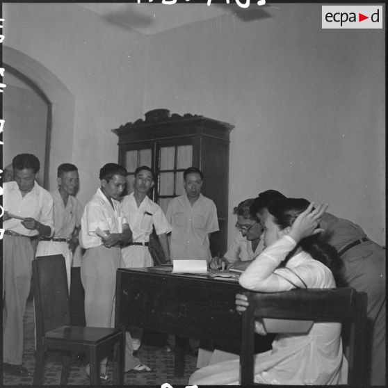 Des réfugiés sont informés des conditions de leur départ au centre d'évacuation d'Hanoï.	