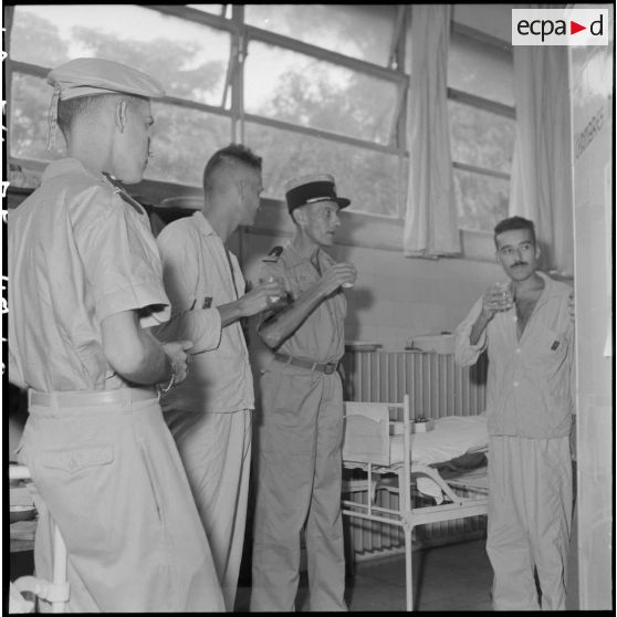 Le colonel Lalande partage un verre avec des légionnaires du 3e REI hospitalisés à l'hôpital Lanessan après les avoir décorés.