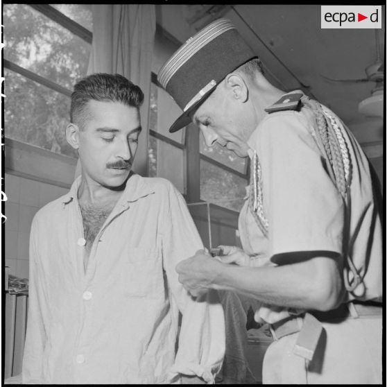 Le colonel Lalande décore un légionnaire du 3e REI hospitalisé à l'hôpital militaire Lanessan.