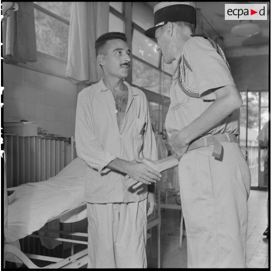 Le colonel Lalande décore un légionnaire du 3e REI hospitalisé à l'hôpital militaire Lanessan.