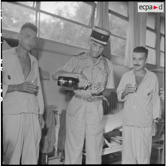 Le colonel Lalande partage un verre avec des légionnaires du 3e REI hospitalisés à l'hôpital Lanessan après les avoir décorés.