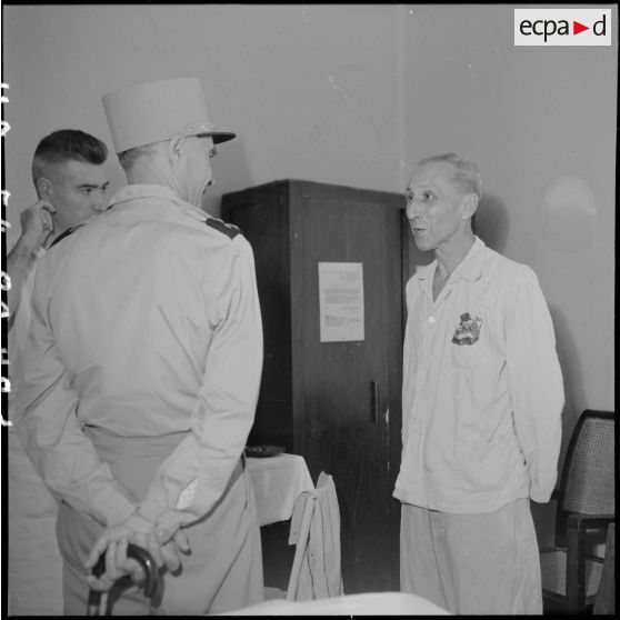 Le général Ely (de dos), commissaire général de France et commandant en chef en Indochine, rend visite à un homme hospitalisé à Hanoï.