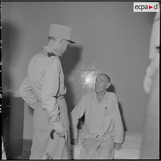 Le général Ely, commissaire général de France et commandant en chef en Indochine, en conversation avec un homme hospitalisé à l'hôpital militaire Lanessan.