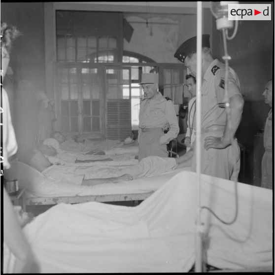 Le général Ely (au centre), commissaire général de France et commandant en chef en Indochine, en conversation avec un homme hospitalisé à l'hôpital militaire Lanessan.