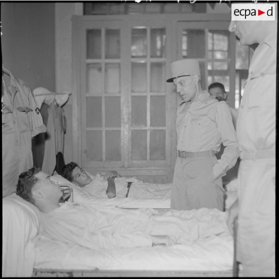 Le général Ely, commissaire général de France et commandant en chef en Indochine, en conversation avec un homme hospitalisé à l'hôpital militaire Lanessan.