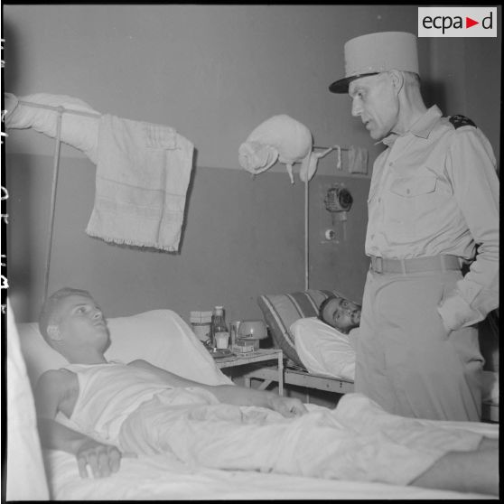 Le général Ely, commissaire général de France et commandant en chef en Indochine, en conversation avec un homme hospitalisé à l'hôpital militaire Lanessan.