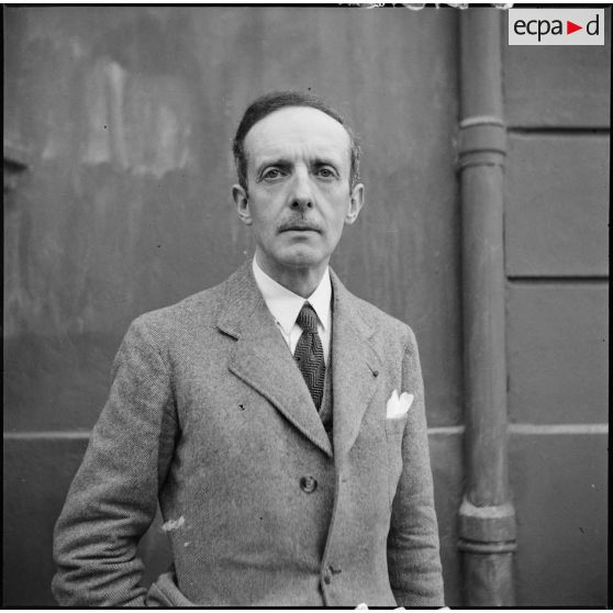 Portrait en civil du général de brigade aérienne René Chambe, secrétaire à l'information auprès du commandement en chef civil et militaire.