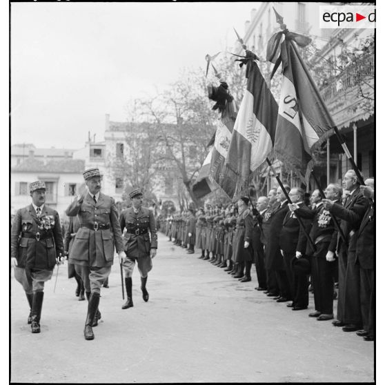 Le général d'armée Henri Giraud salue les emblêmes d'anciens combattants.