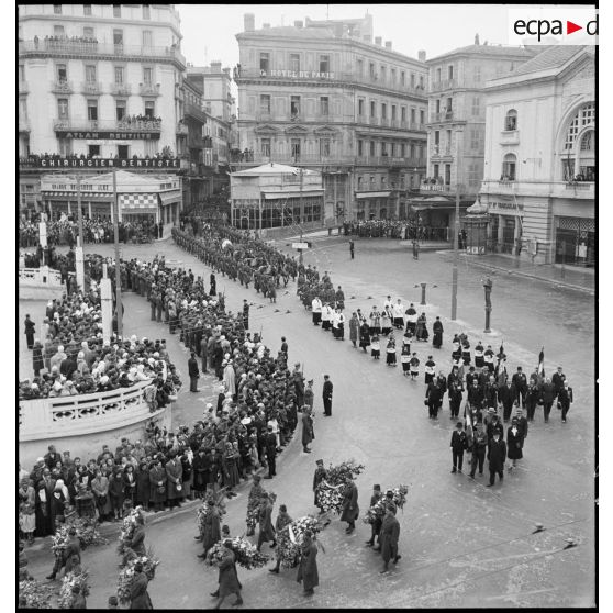 Cérémonie d'obsèques du général de division Marie-Joseph Welvert, commandant la DMC (division de marche de Constantine) : vue en plongée sur les porteurs de gerbes et les associations d'anciens combattants dans le défilé du cortège funèbre.