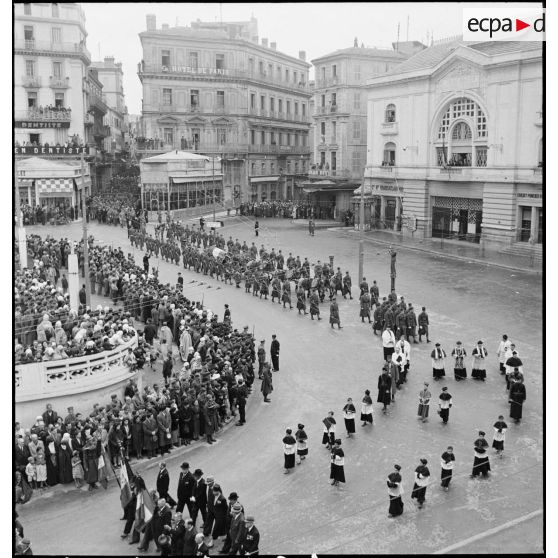 Cérémonie d'obsèques du général de division Marie-Joseph Welvert, commandant la DMC (division de marche de Constantine) : vue en plongée sur les associations d'anciens combattants et le clergé dans le défilé du cortège funèbre.