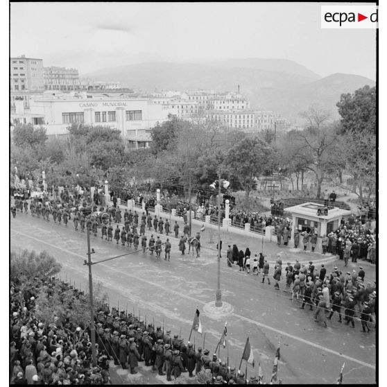 Cérémonie d'obsèques du général de division Marie-Joseph Welvert, commandant la DMC (division de marche de Constantine) : vue en plongée sur le cercueil du défunt disposé sur un canon hippomobile du 67e RAA (régiment d'artillerie d'Afrique), suivi par la famille et les autorités militaires.