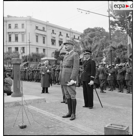 Le général d'armée Henri Giraud, commandant en chef civil et militaire, lors de la cérémonie d'obsèques du général de division Marie-Joseph Welvert, salue l'arrivée du cercueil du défunt.