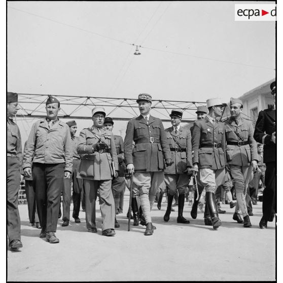 Le général d'armée Henri Giraud, commandant en chef civil et militaire, est guidé par un colonel, responsable du montage, lors de sa visite sur le port d'Alger au cours de la livraison des premiers matériels américains à l'armée française.
