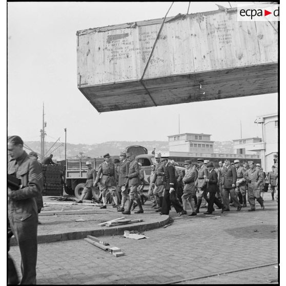 Le général d'armée Henri Giraud, commandant en chef civil et militaire, poursuit sa visite accompagné d'officiers français et américains alors que le matériel et les véhicules américains destinés à l'armée française sont déchargés sur les quais.
